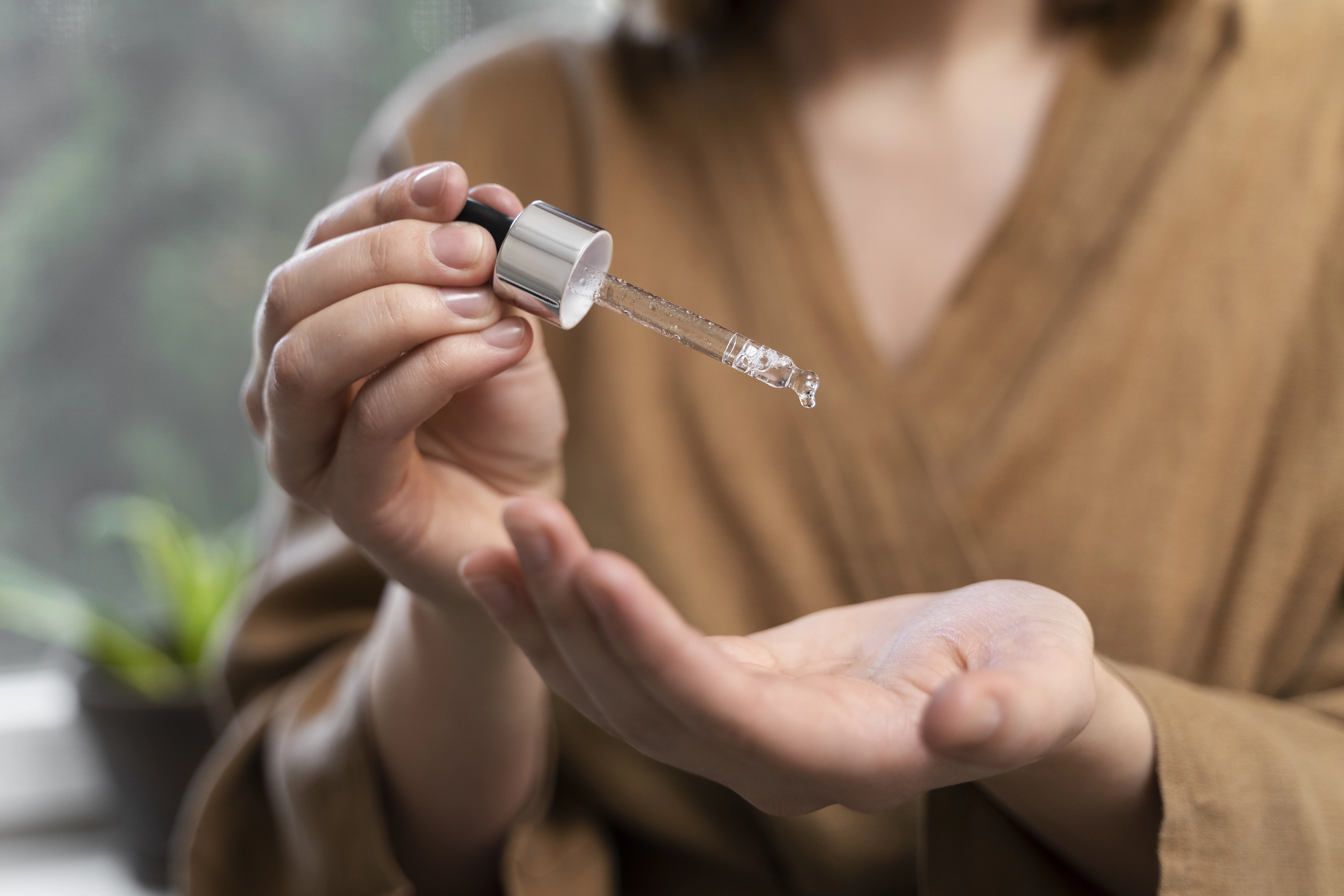 一位女性正在使用外泌體保養品,將精華液滴在手上,強調產品的滴管設計與使用方式