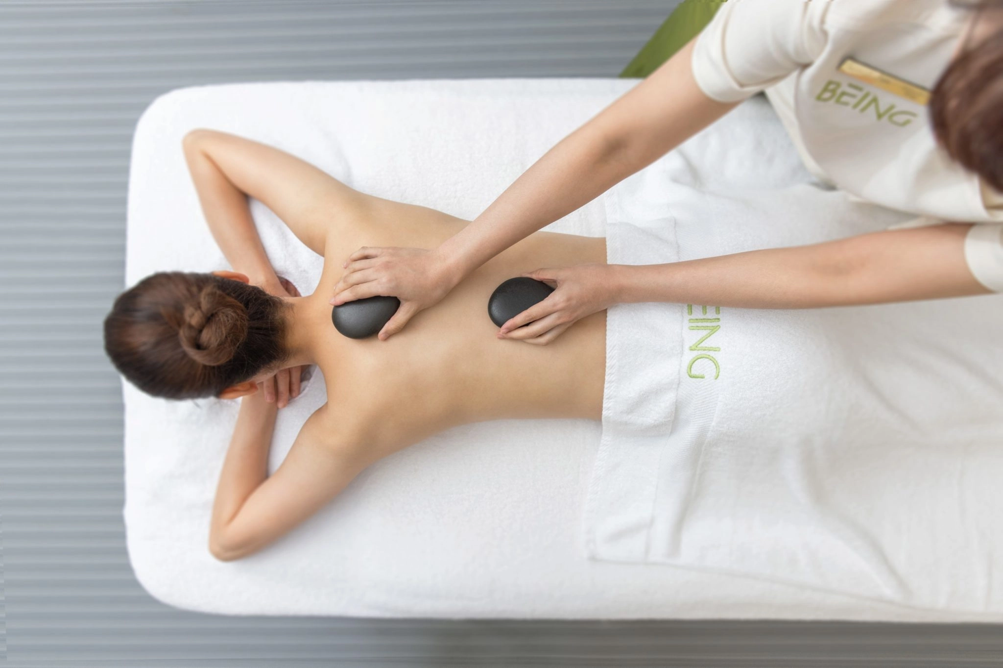 台北SPA推薦 BEING SPA 一位正趴著享受能量石按摩的女性